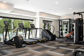 A gym with treadmills, elliptical machines, and weight machines.